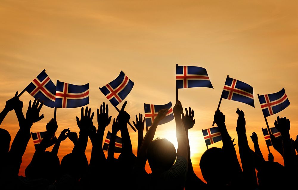 Group of People Waving Icelandic Flags in Back Lit