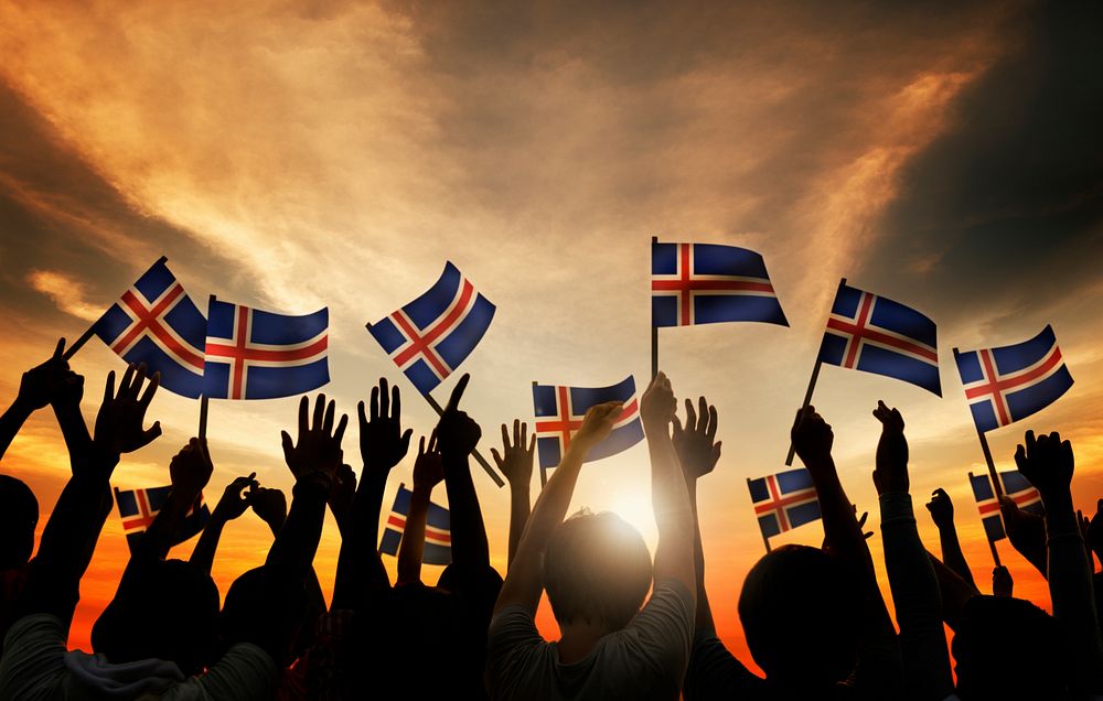 Group of People Waving Icelandic Flags in Back Lit