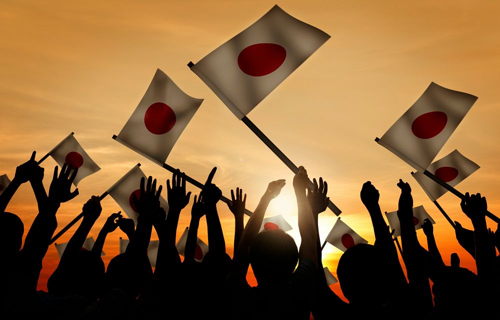 Group of People Waving Japanese Flags in Back Lit