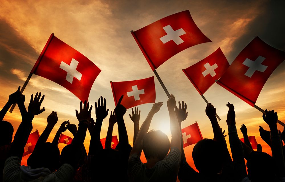 Silhouettes of People Holding Flag of Switzerland