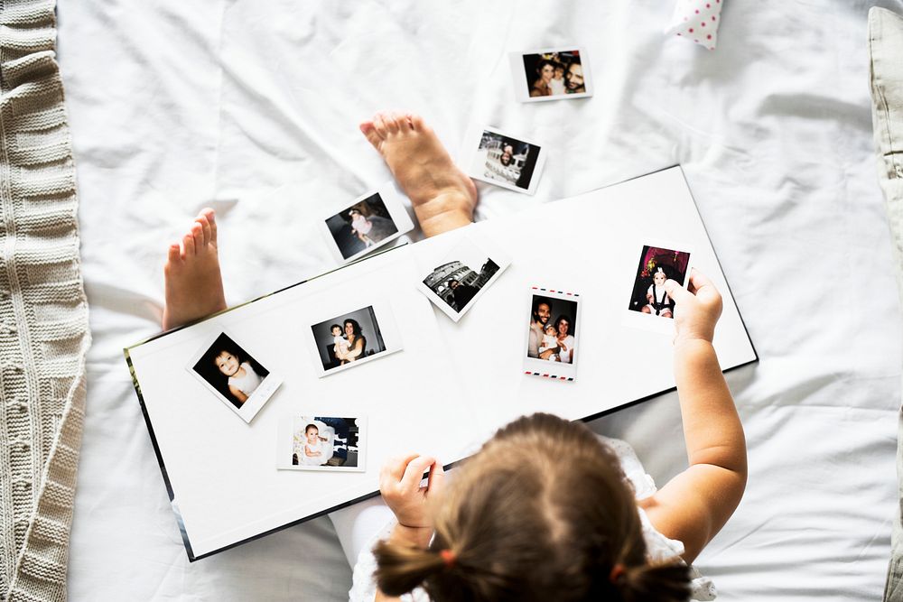 Little girl looking her family photo in album