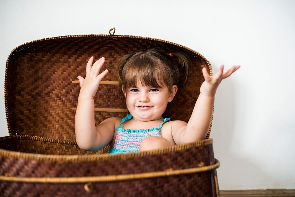 Little girl playing inside a basket