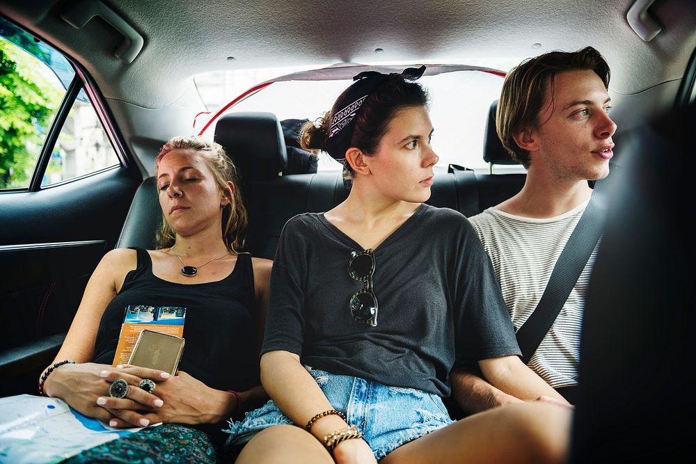 Group of tourist sitting in the taxi backseat doing sight seeing tour