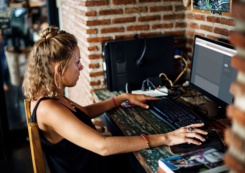 Side view of a caucasian woman sitting using computer