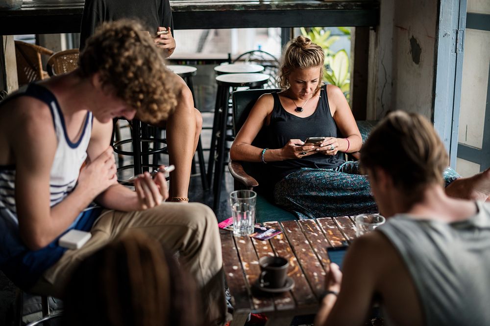 Group of caucasian people sitting using mobile phone social network
