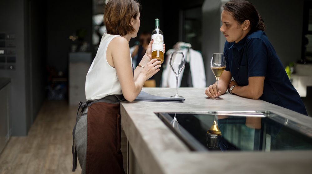 Bartender showing a wine to customer at the bar