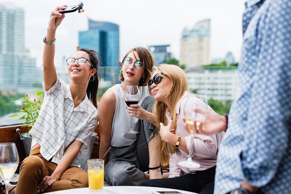 Women taking selfie with friends