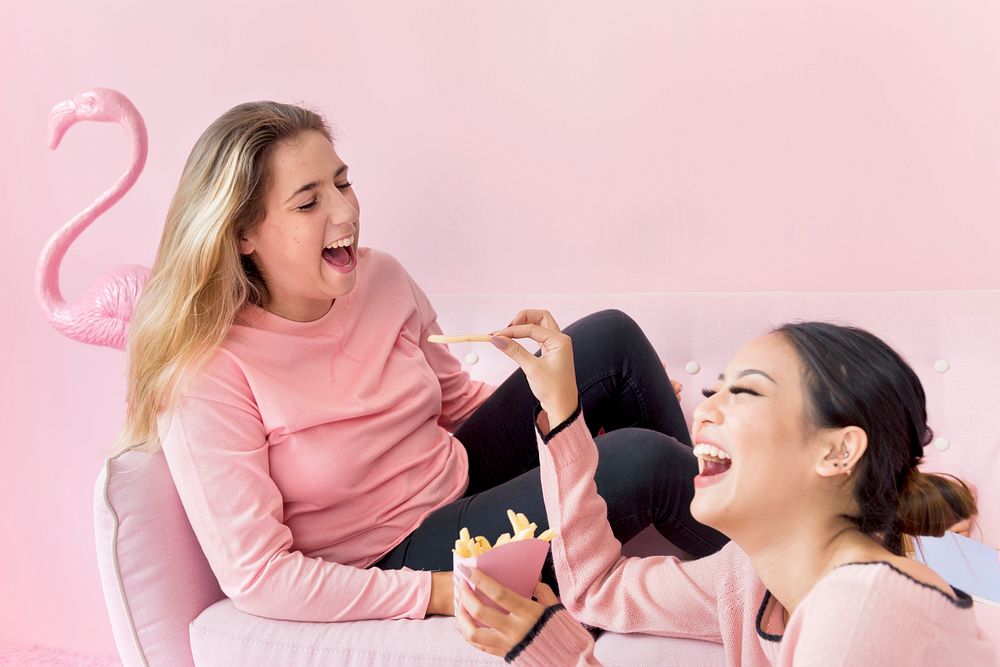 Girl friends in pink laughing with each other
