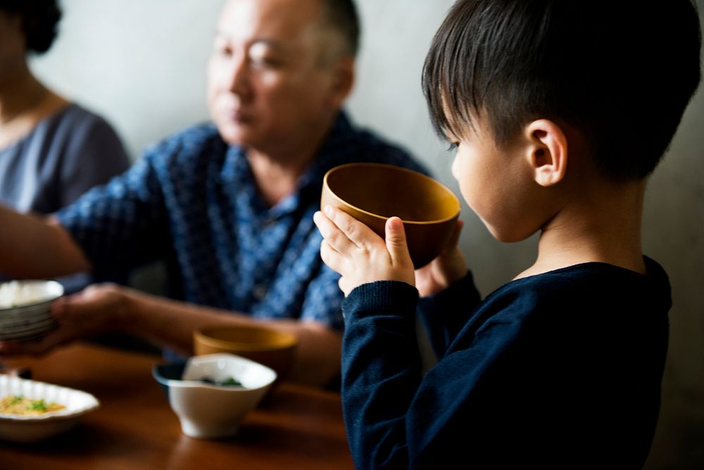 Japanese boy holding a bowl of soup
