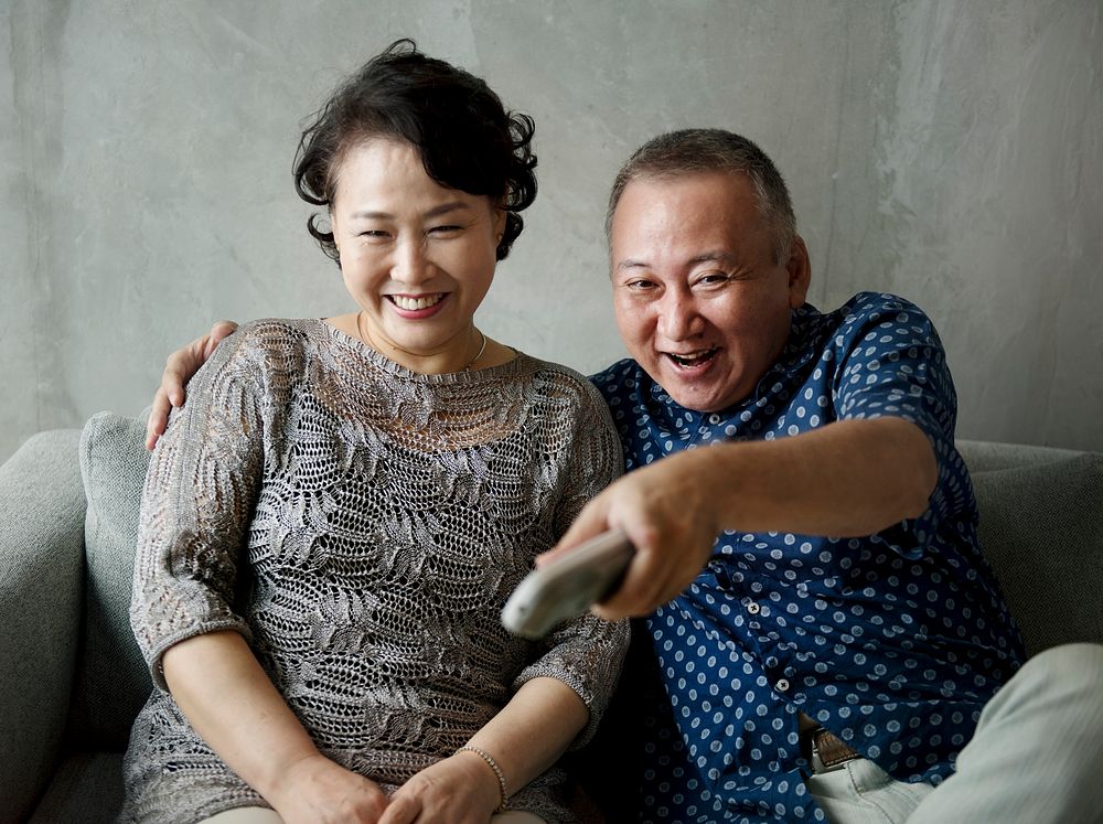 Asian senior couple sitting together at sofa