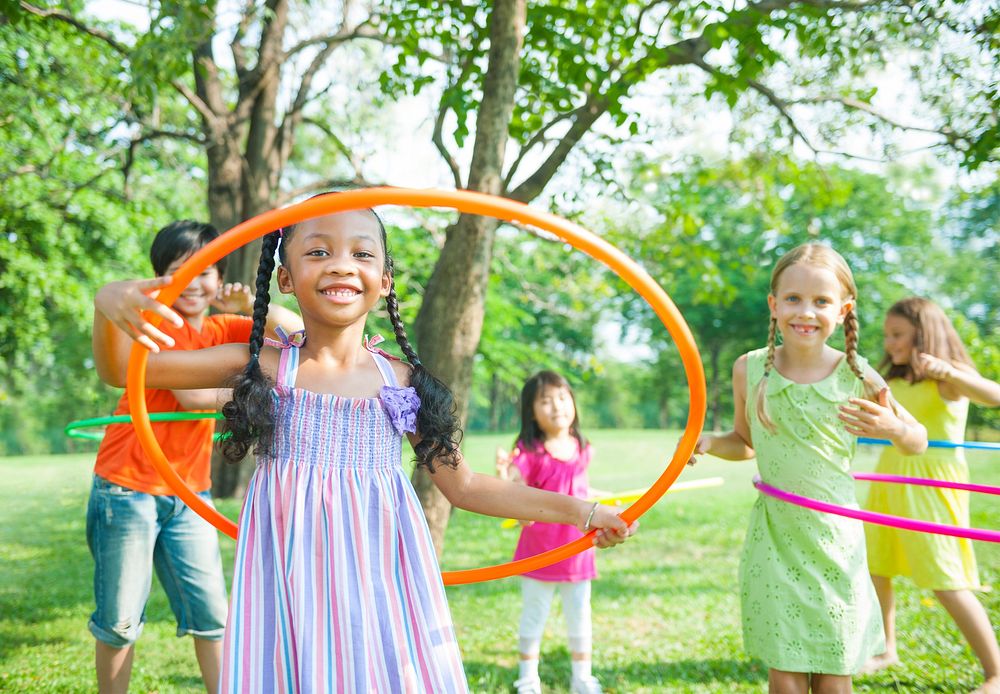 Cute diverse kids playing with hula hoops