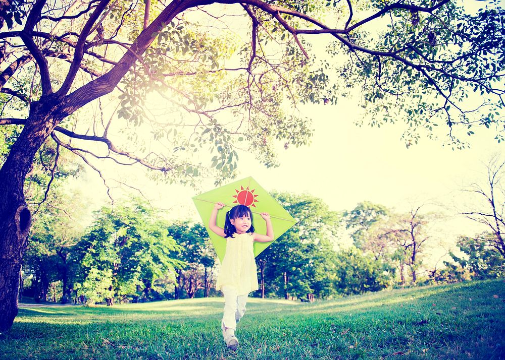 Cheerful Child Playing Kite Outdoors