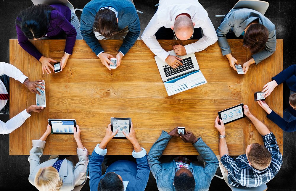 Business people using digital devices in a meeting