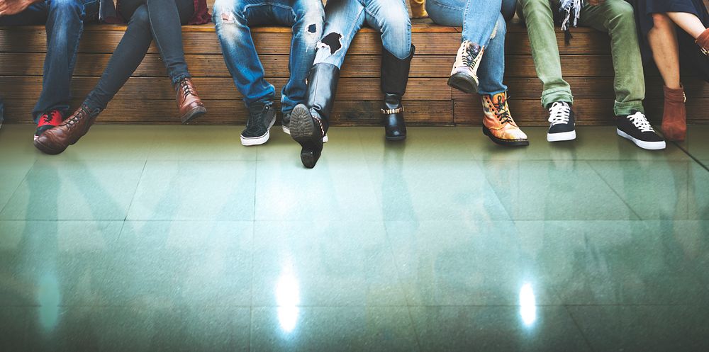 Closeup group of people legs sitting together with green floor