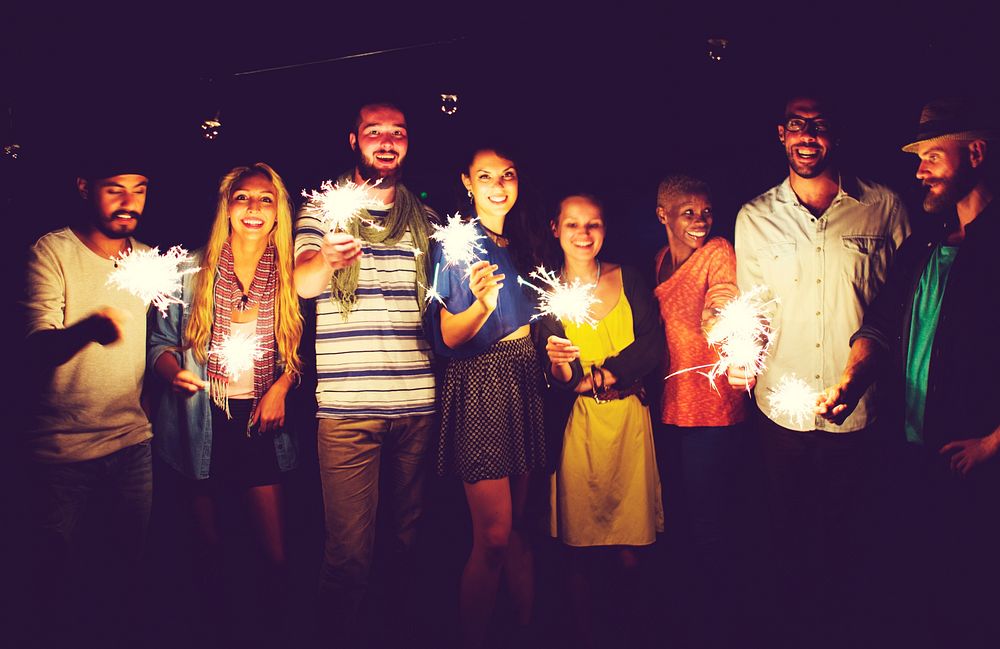 Friends holding sparklers in the night