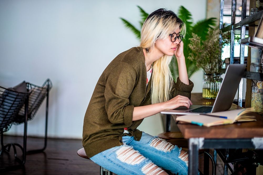 Blonde Asian woman working on a laptop