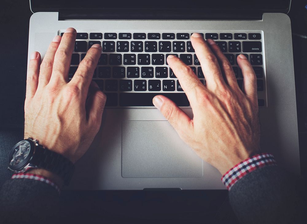 Closeup of hands using laptop keyboard