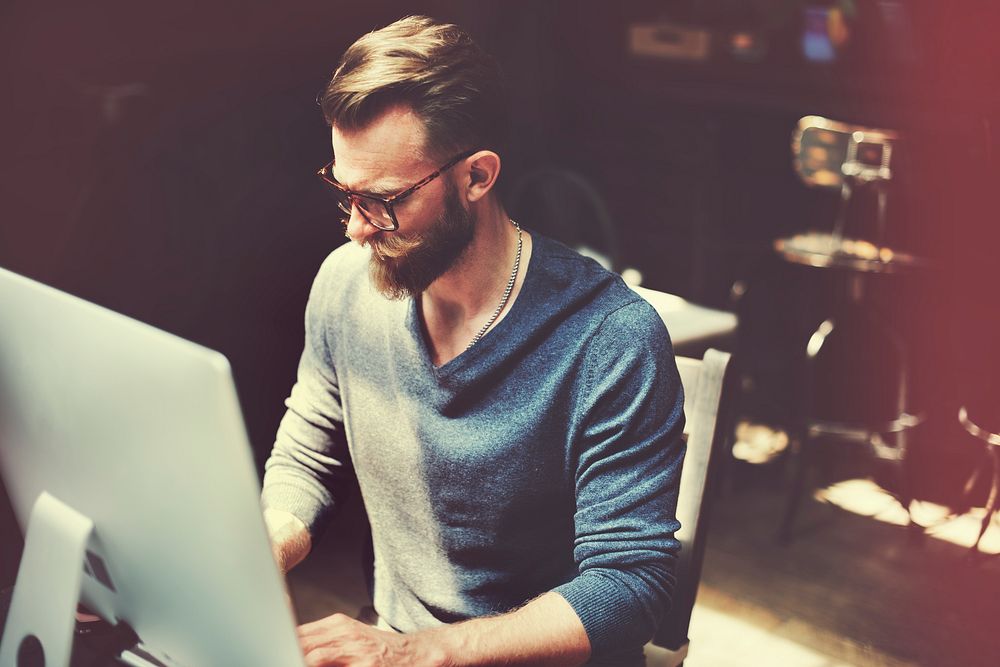 Caucasian man sitting working on computer pc