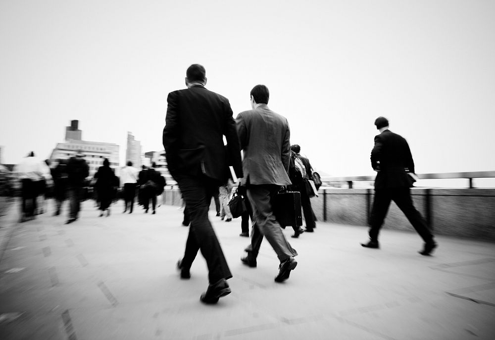 Black and white blurred scene of crowded people walking in a rush