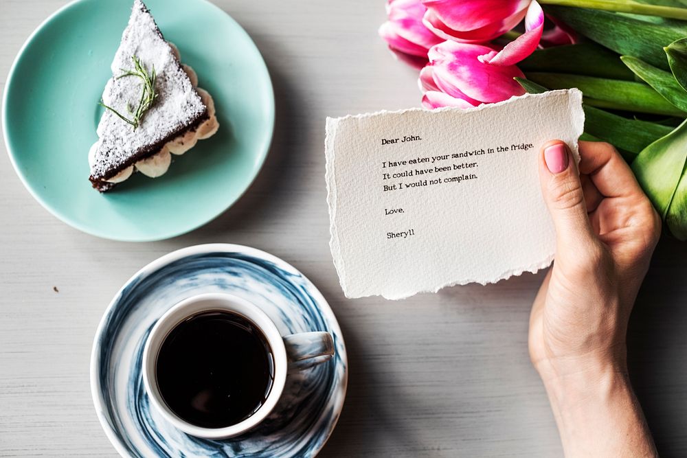 Hand Holding Message Note Paper with Bakery and Coffee Cup