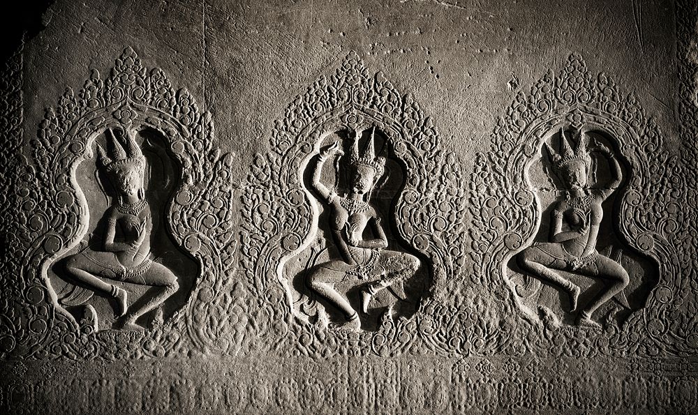 Ancient dancing characters engraved on a wall.