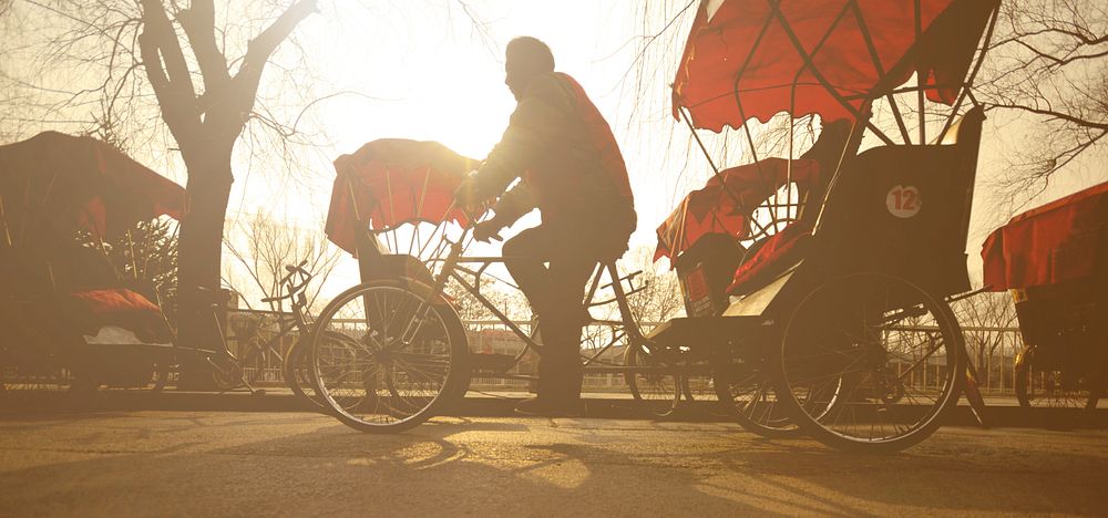 Man Riding a Rickshaw China Concept