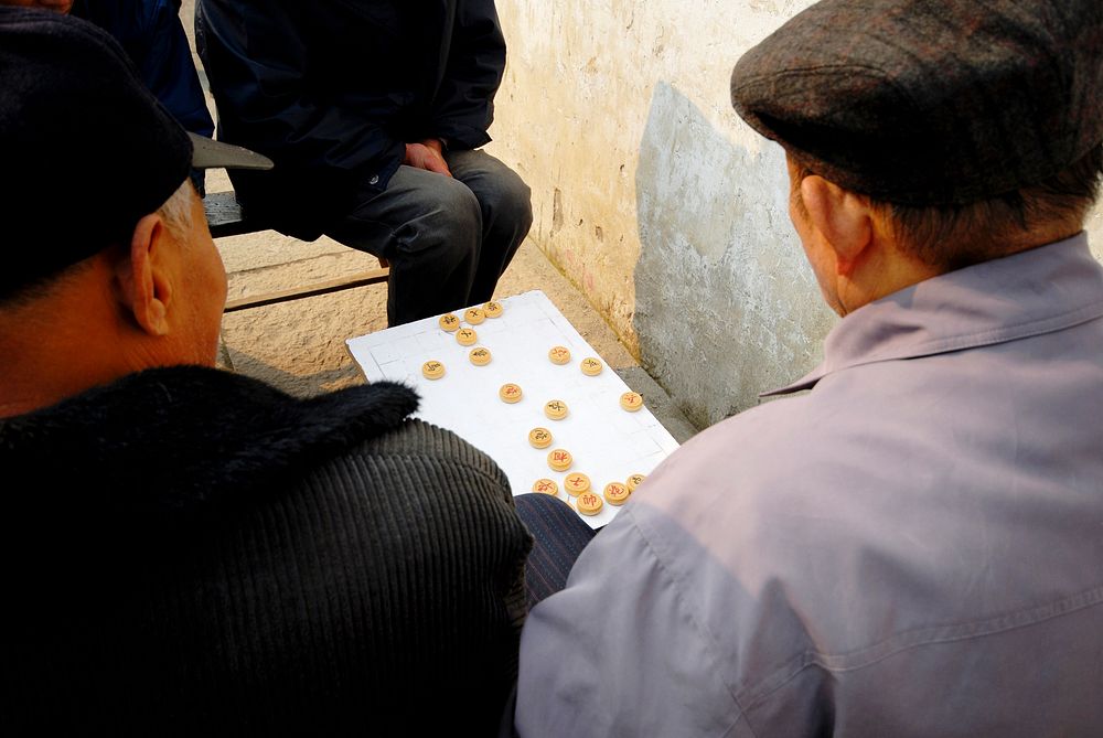 Chinese men enjoying a game of Chinese chess on the street.