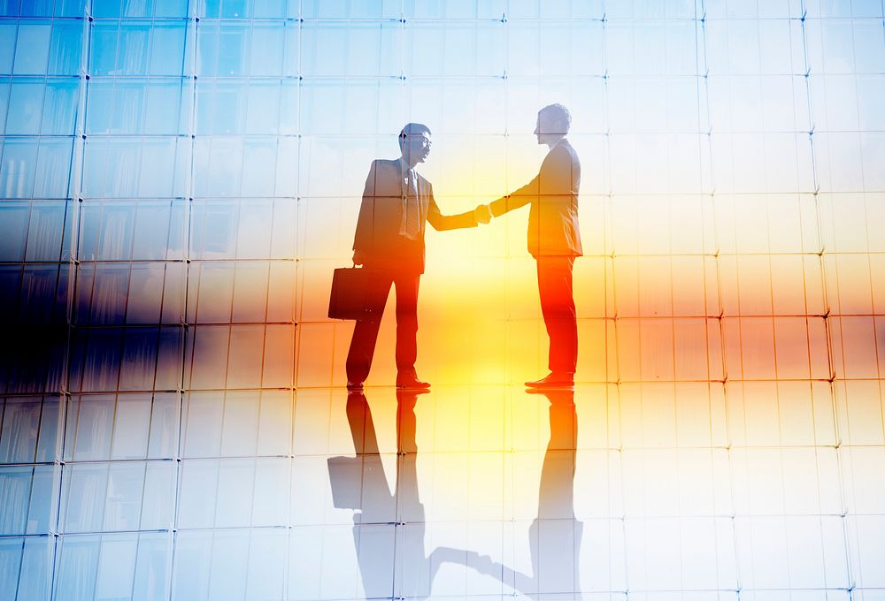 Silhouette of business people handshaking