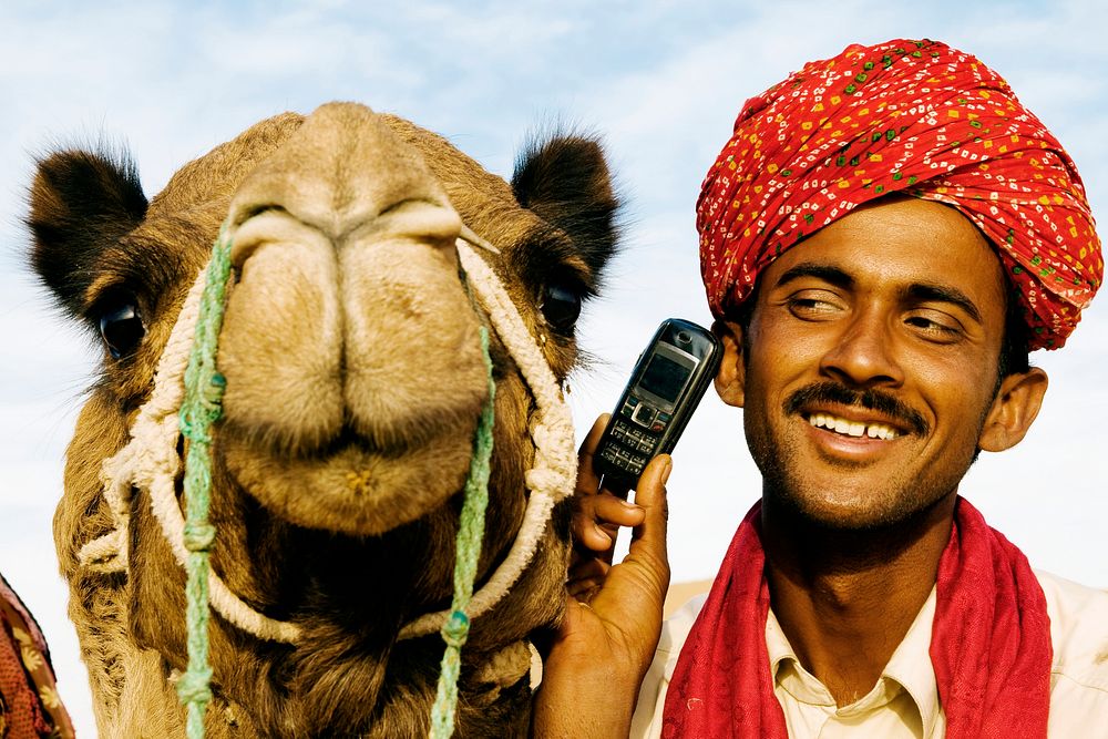 Indian man and camel on the phone, Rajasthan, India.