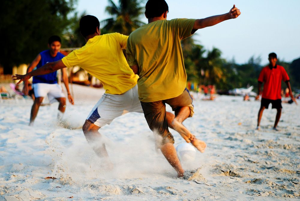 Boys playing soccer on a tropical beach