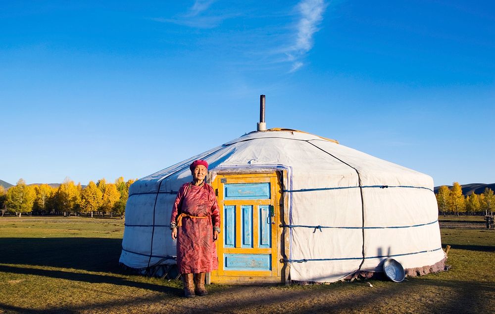 Mongolian lady standing in front of a tent