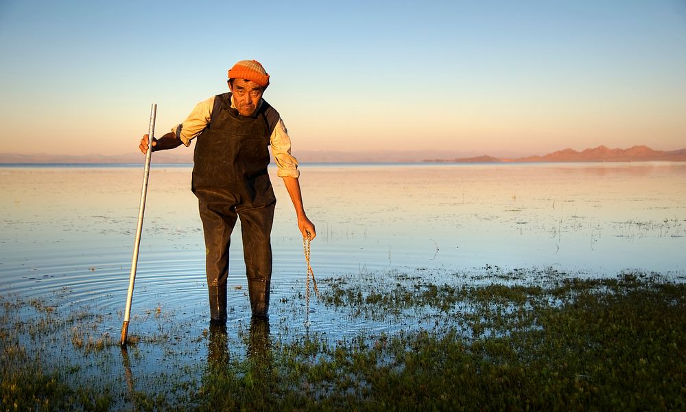 Mongolian man cleaning a lake