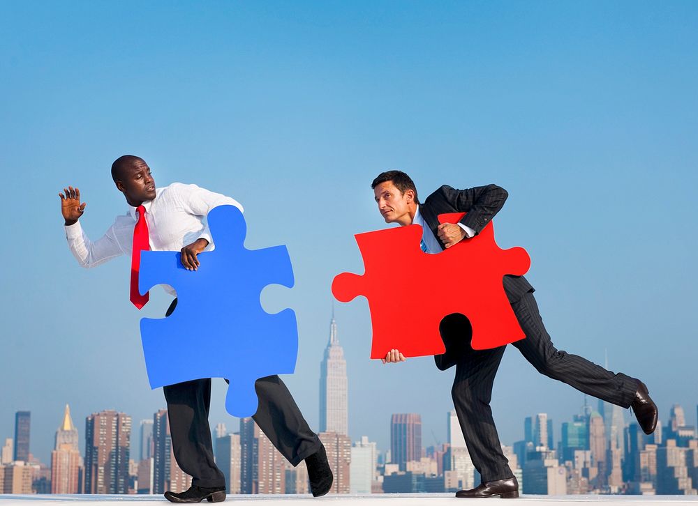 Two Businessmen in an Urban Scene with Puzzle Piece