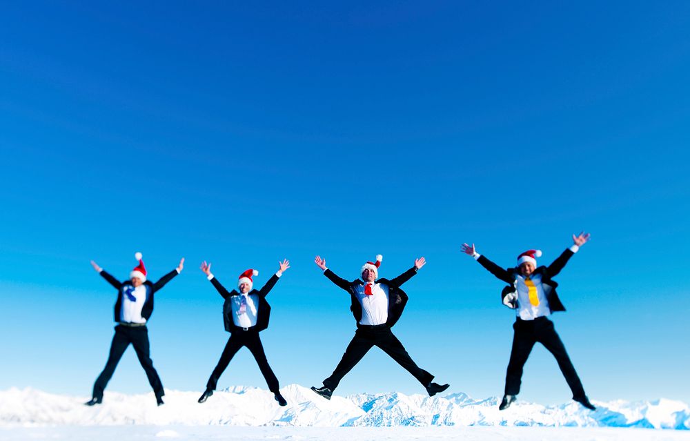 Businessmen celebrating christmas on a snow covered mountain.