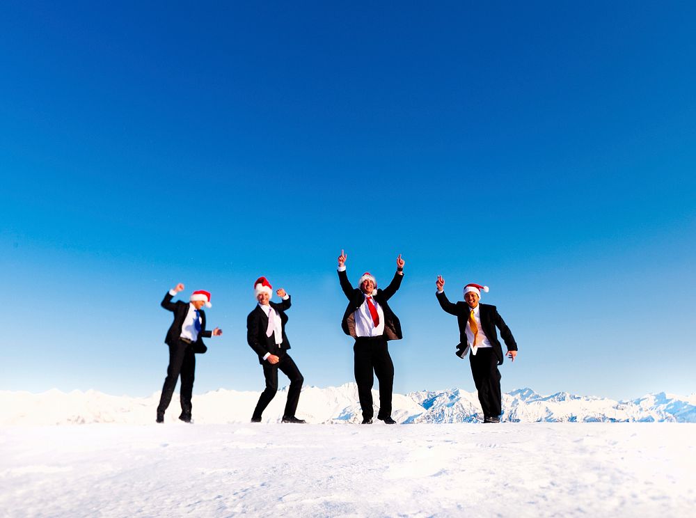 Businessmen celebrating christmas on a snow covered mountain.