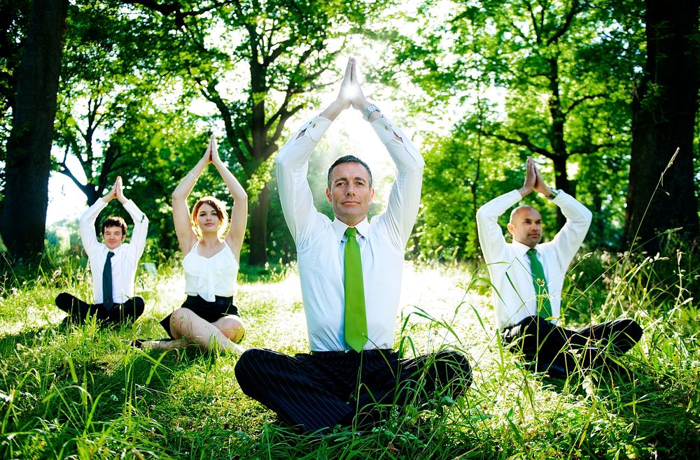 Business people doing yoga outdoors.