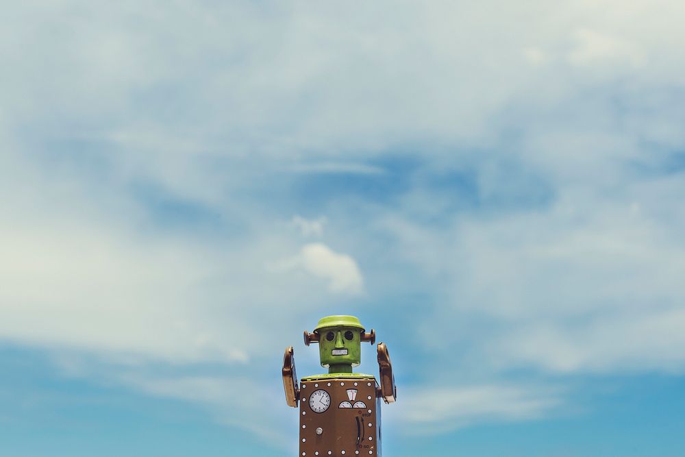 Closeup of robot toy with cloudy blue sky scenic