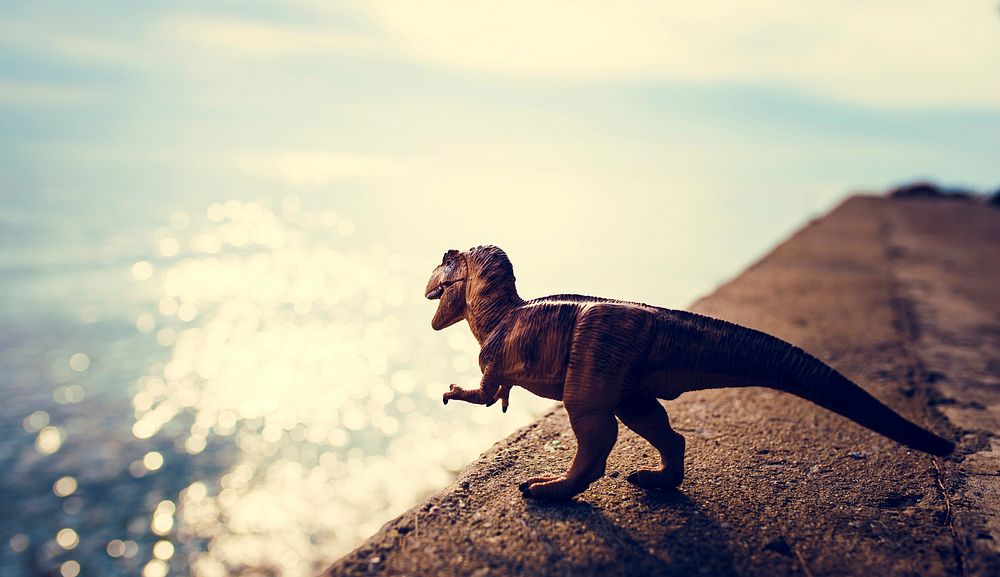 T Rex Dinosaur Toy Model Standing Next To Ocean