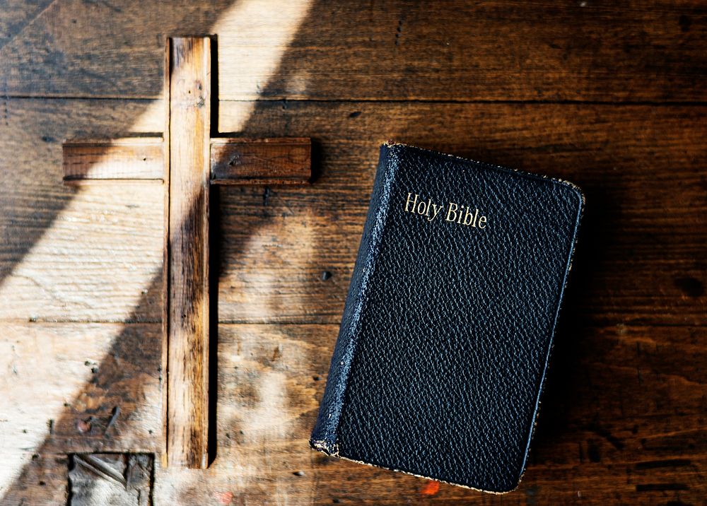 Sunlight on a Bible and wooden cross 