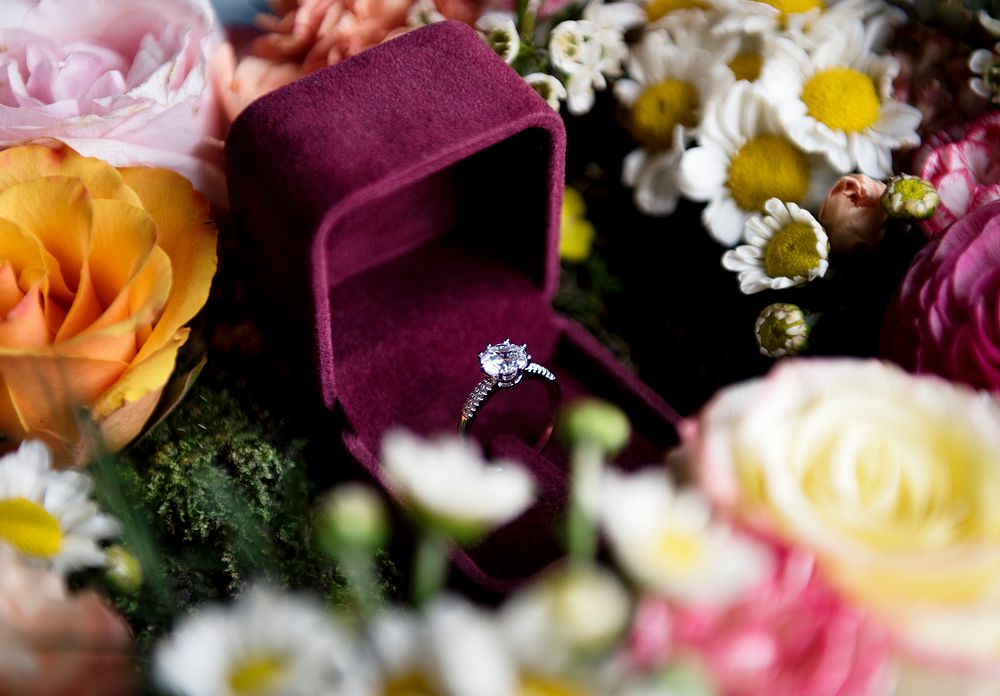 Cloeseup of Wedding Ring in Red Box with Flowers Arrangement Decoration