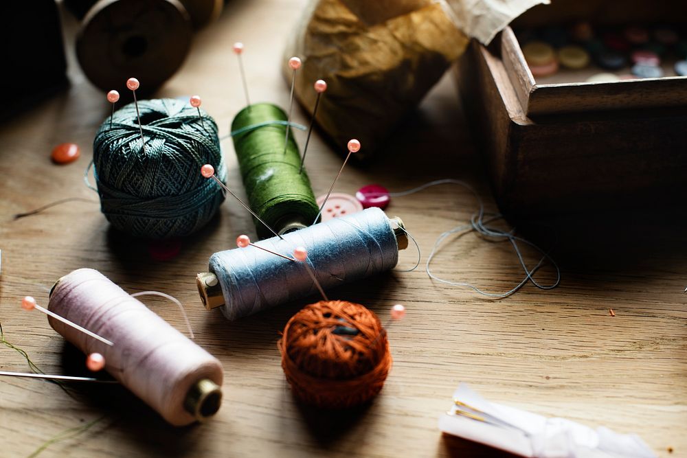 Sewing spools tools on a wooden table