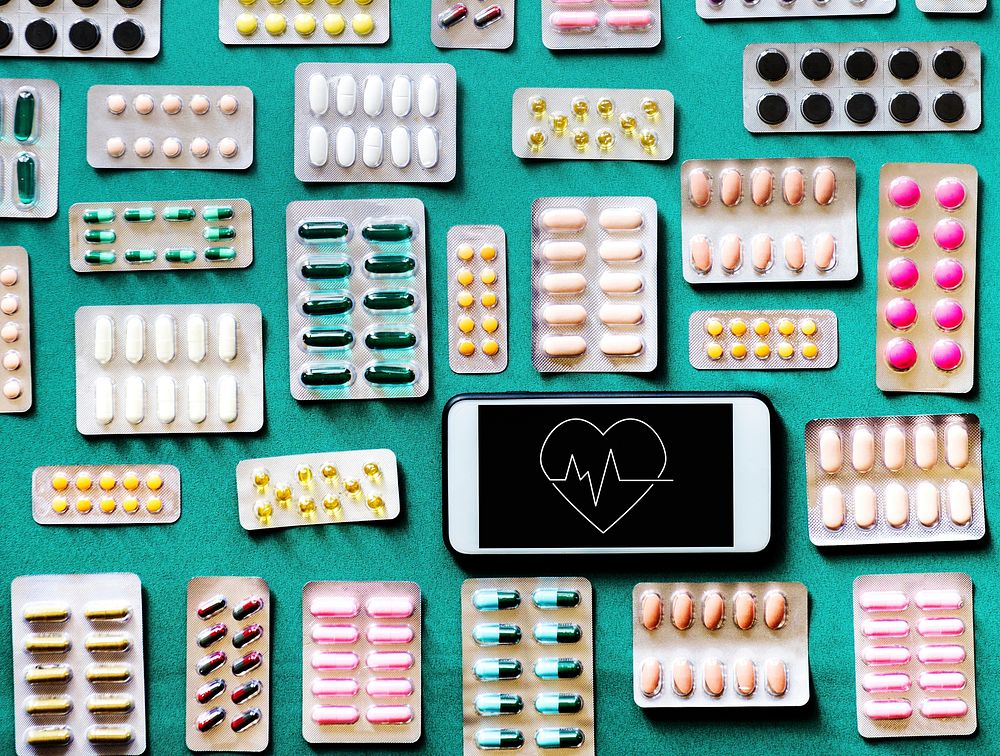 Pills and tablets with a mobile phone with a heart rate icon