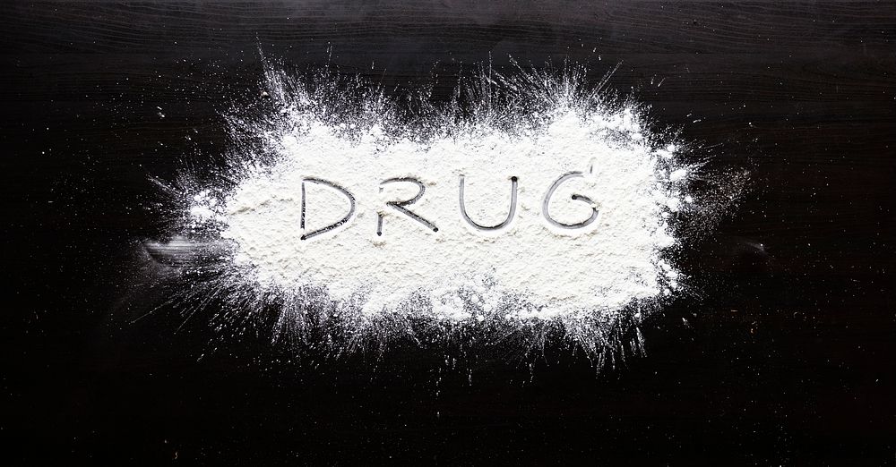 Drug powder word on black background