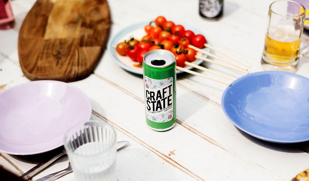 Beer can on wooden table with dishes