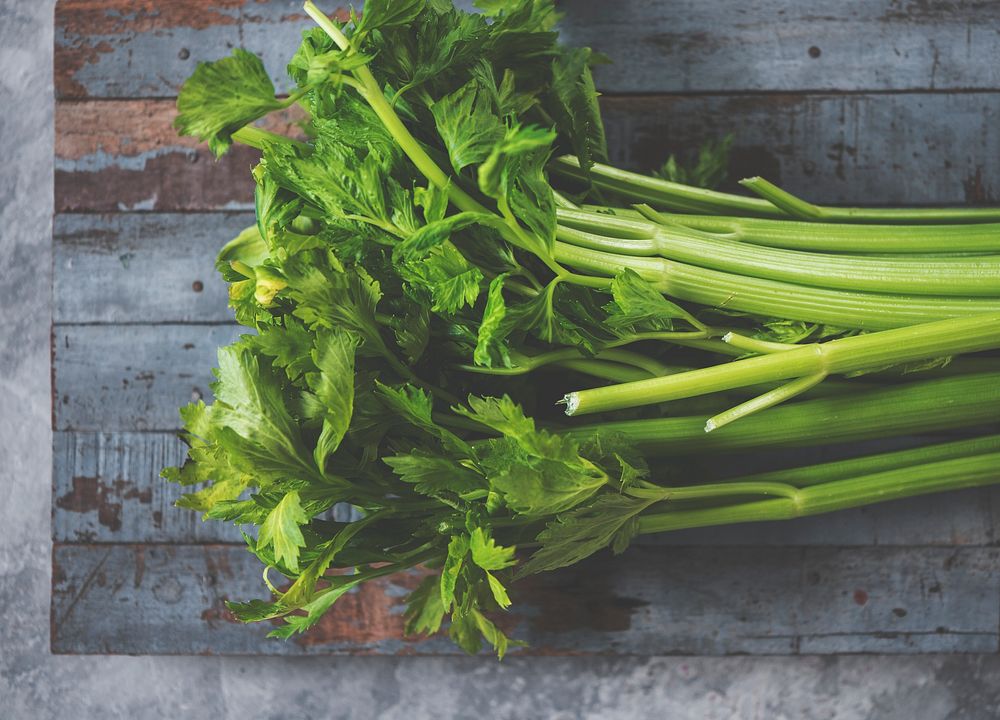 Green fresh celery on a wooden floor