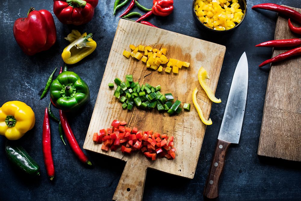 Chopped variation bell pepper on a wooden cutting board