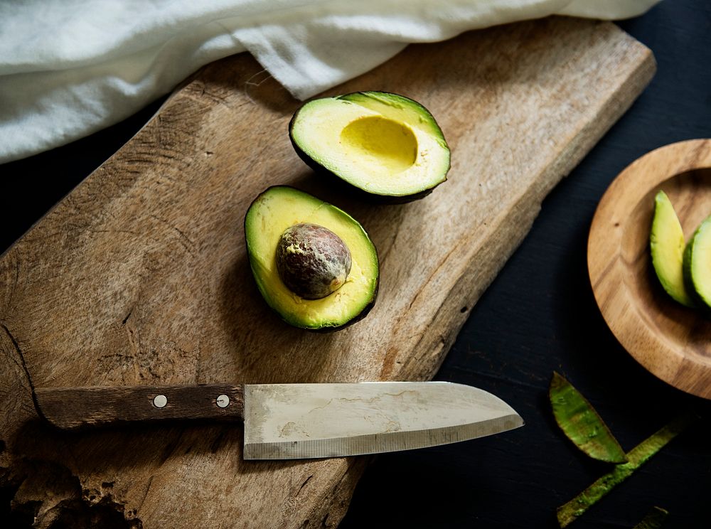Aerial view of fresh avocado on wooden cut board