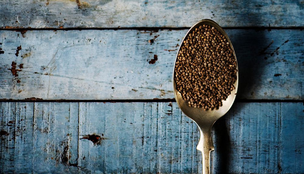 Quinoa in a spoon on a wooden floor