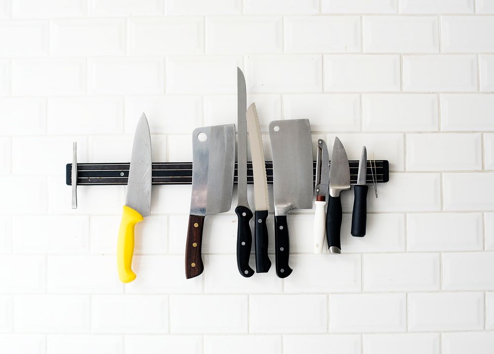 Set of knives hanging on the white wall