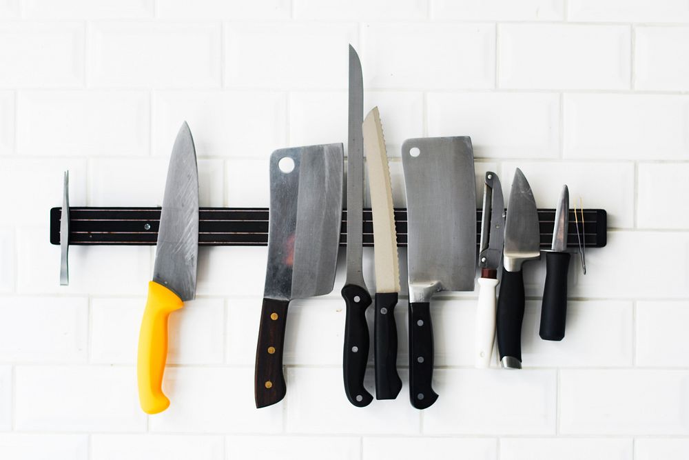 Set of knifes hanging on the white wall